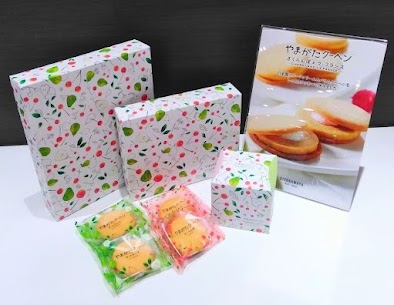 しっとりしたバウムクーヘンとクリームを ソフトなクッキーでサンドした【やまがたクーヘン】✨ 佐藤錦の果汁を使用🍒 さくらんぼとラフランスがちりばめられた パッケージがカワイイ💕 山形のお土産に